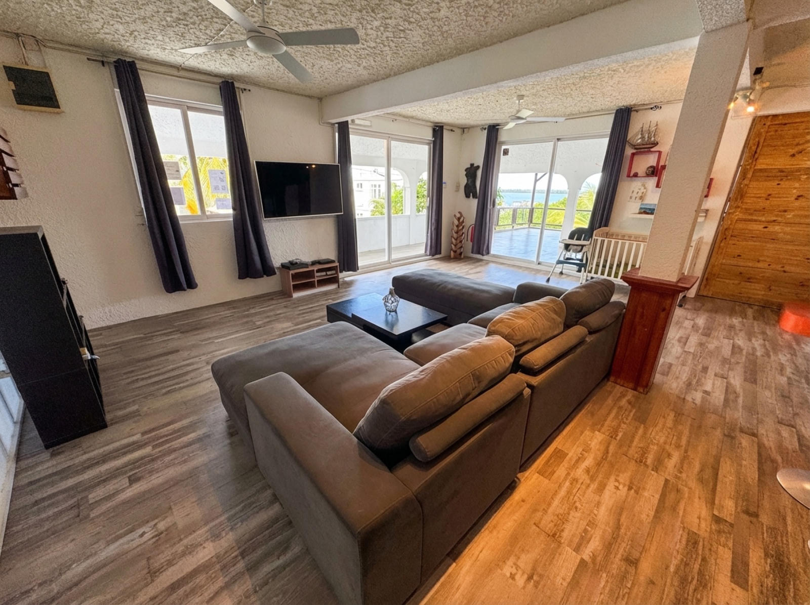 Spacious open-plan living room with large sofa and sliding doors to terrace