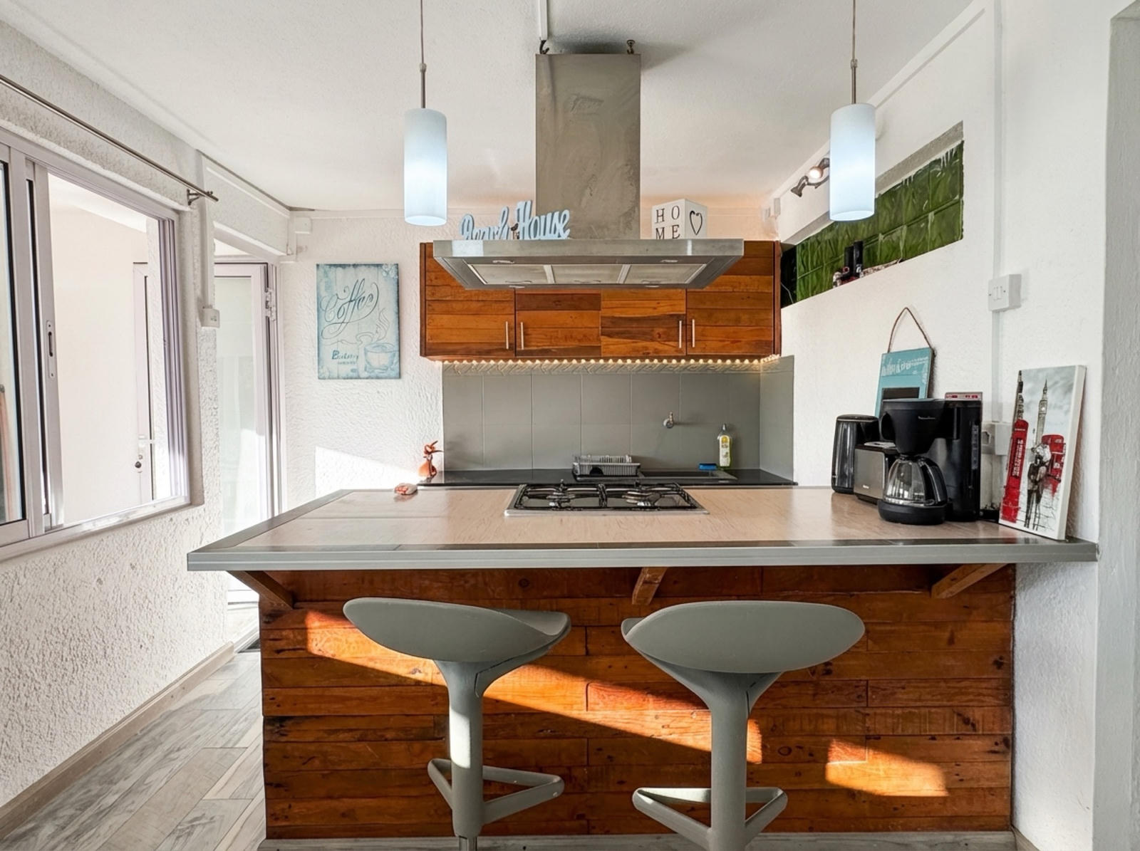Open kitchen with bar stools and Home sign