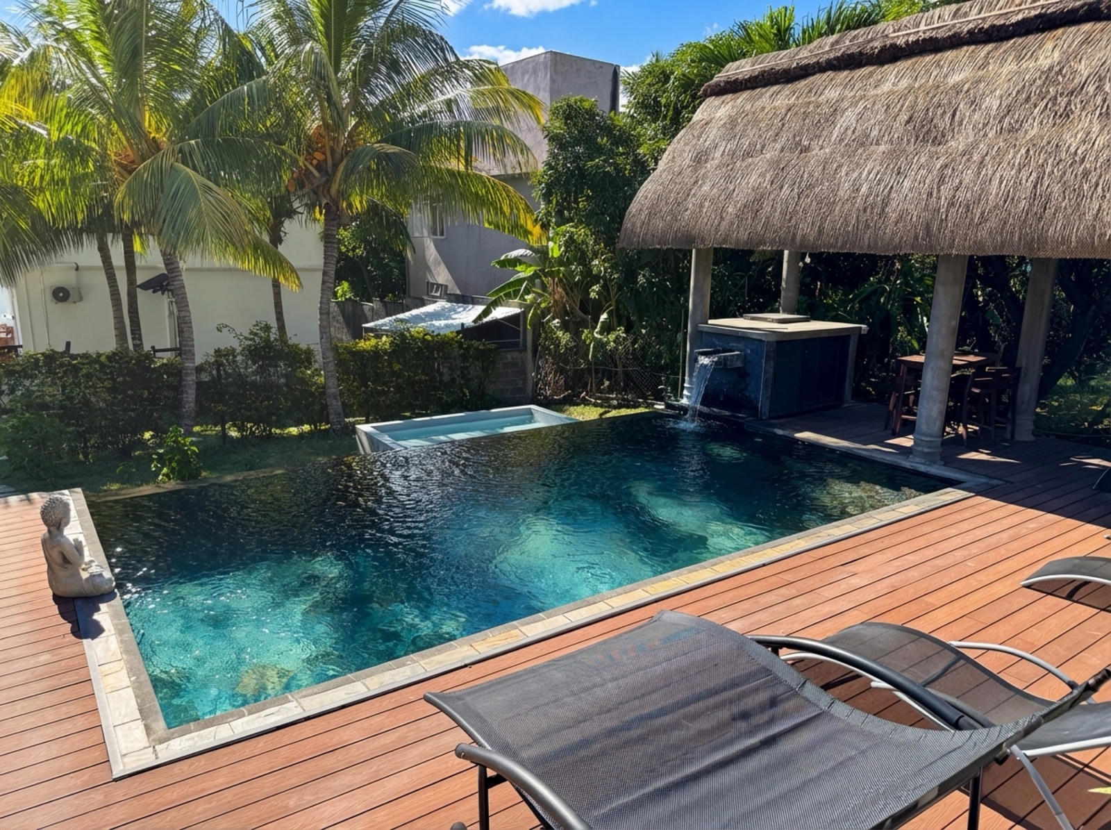 Shared pool with palm trees and thatched kiosk